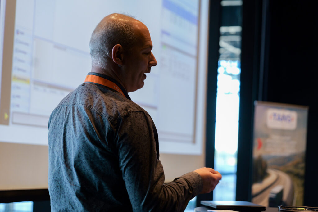 Spreker geeft een softwaredemonstratie voor een projectiescherm tijdens het TANS Kennisevent van 7 april 2026