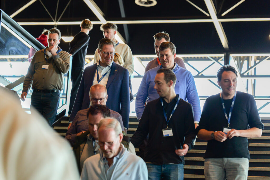 Groep bezoekers met naambadges loopt een trap af tijdens het Kennisevent van 7 april 2026