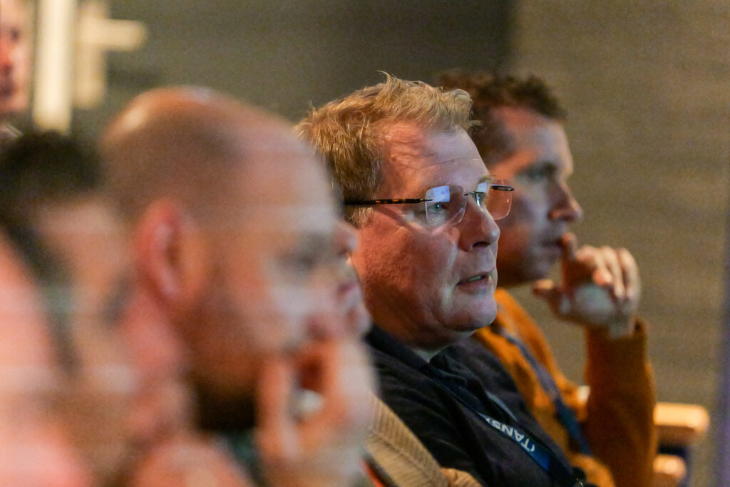 Bezoekers luisteren aandachtig naar een presentatie tijdens het TANS Event van 10 april